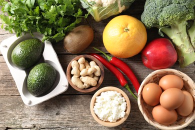 Healthy meal. Different vegetables and raw eggs on wooden table, flat lay