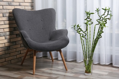 Photo of Vase with green bamboo on floor in room