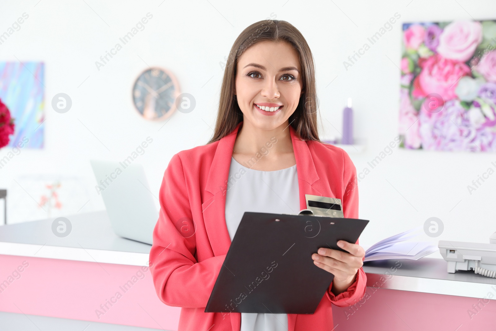 Photo of Beauty salon receptionist with clipboard near desk