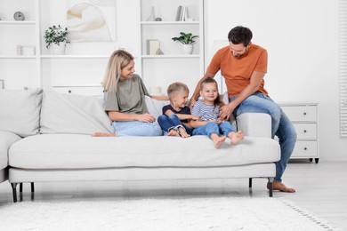 Photo of Happy family spending time together on sofa at home