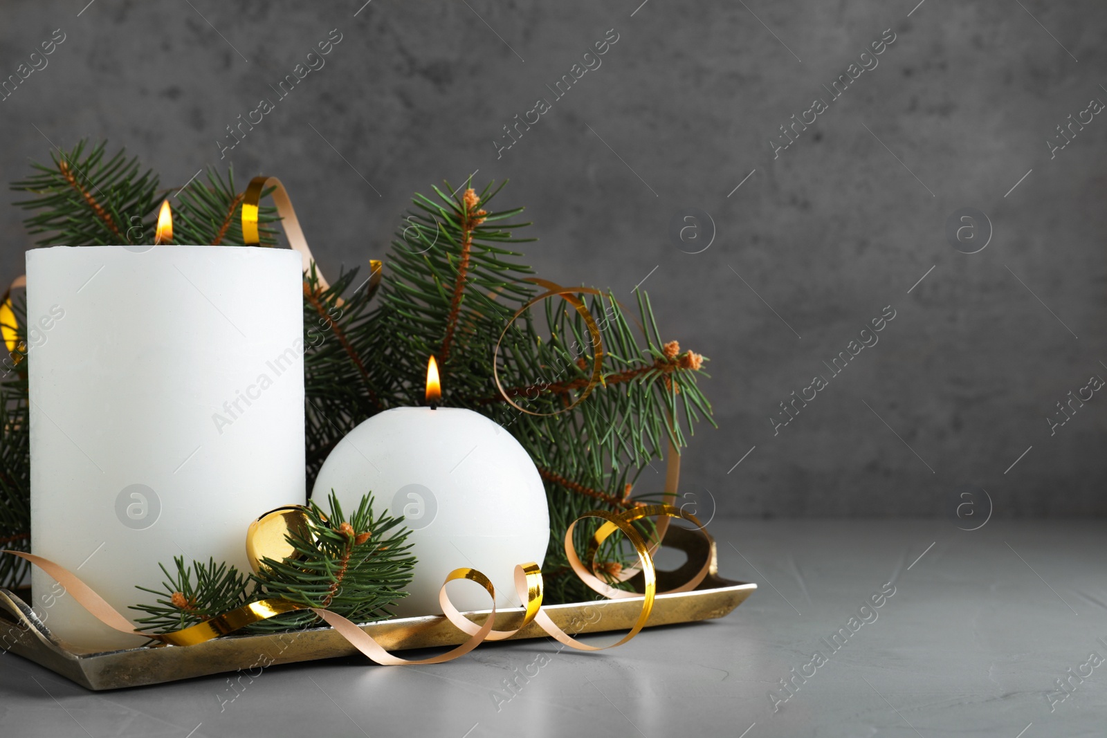 Photo of Beautiful Christmas composition with burning white candles on grey background. Space for text
