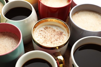 Many cups of different coffees on table, closeup