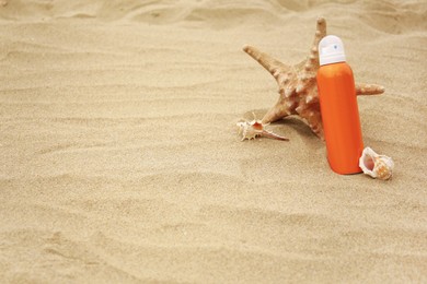 Photo of Sunscreen, starfish and seashells on sand, space for text. Sun protection care