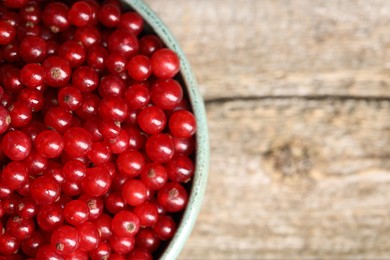 Photo of Ripe red currants in bowl on table, closeup. Space for text