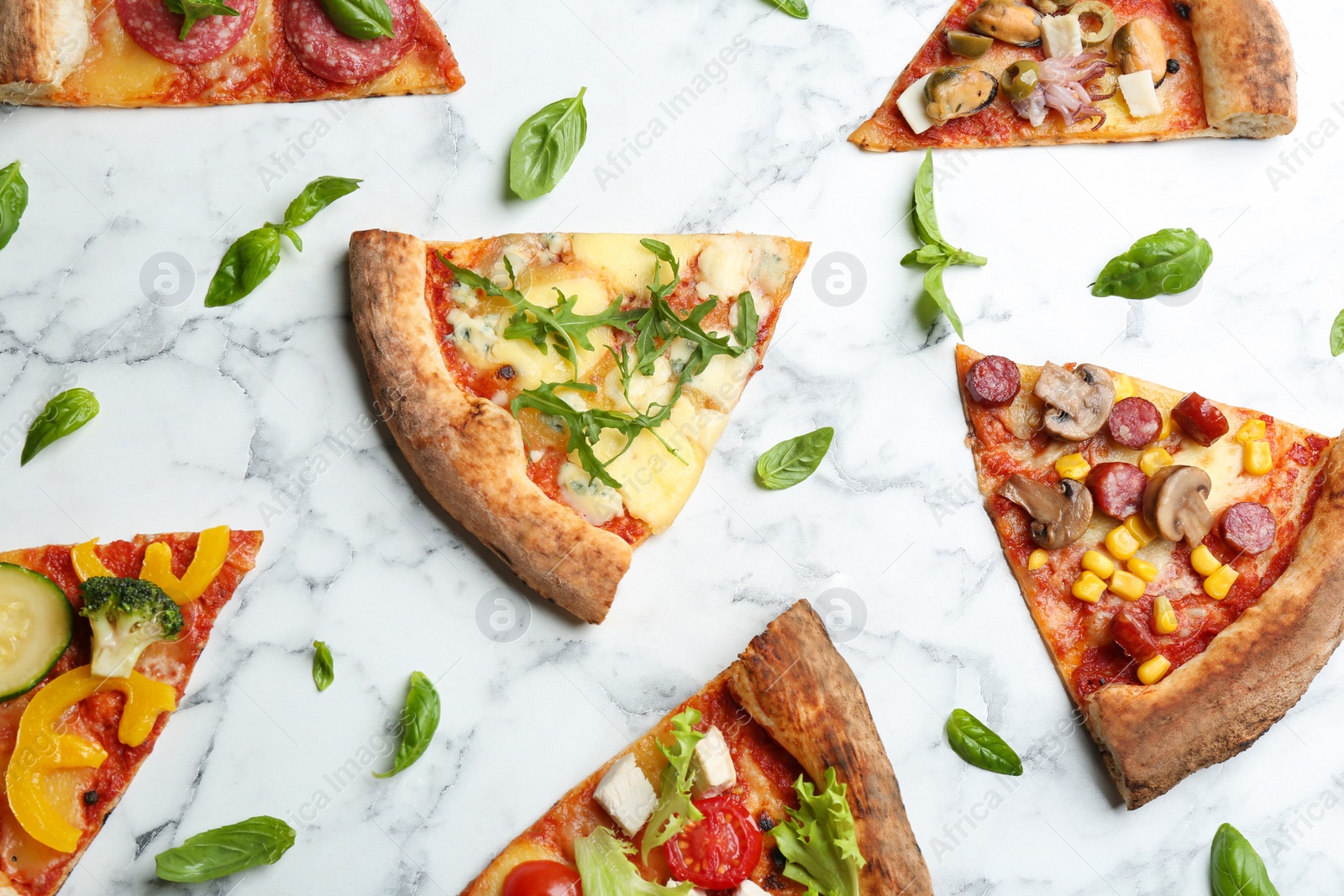 Photo of Flat lay composition with slices of different delicious pizzas on white marble table