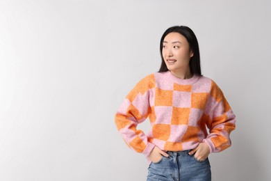 Portrait of smiling woman on light background. Space for text