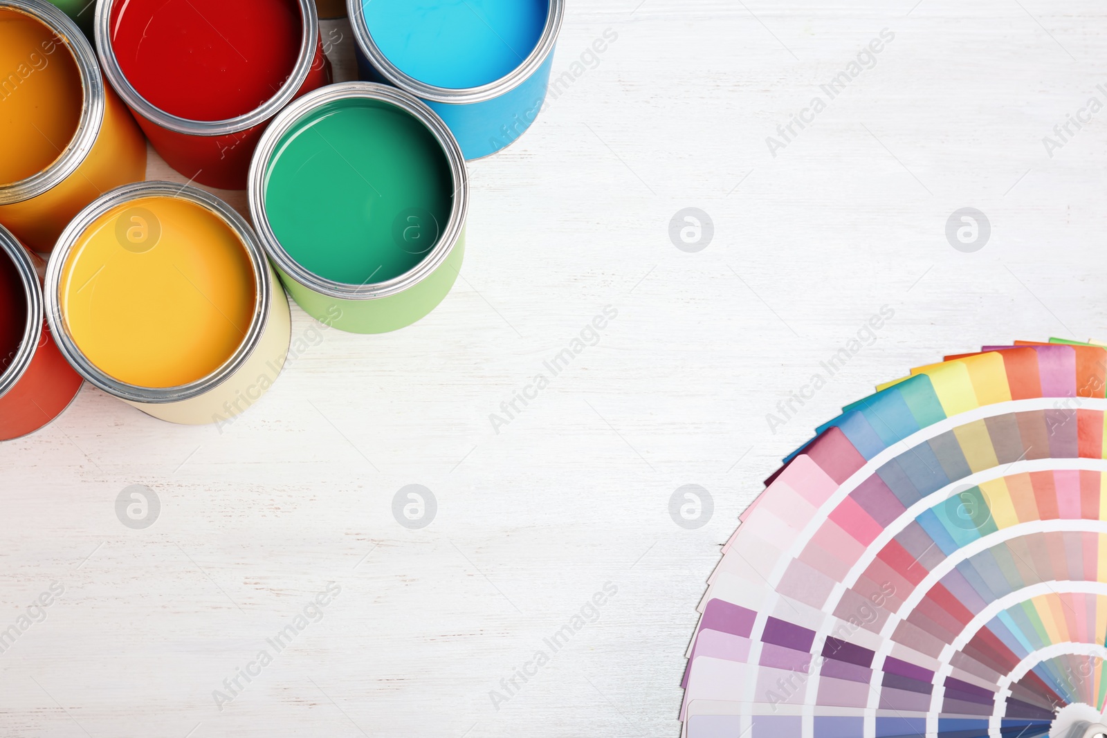 Photo of Flat lay composition with paint cans and color palette on wooden background. Space for text