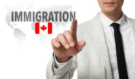 Image of Immigration. Businessman touching digital screen with word and flag of Canada on white background, closeup