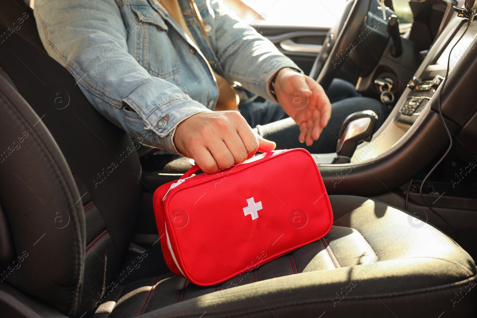 Photo of Man with first aid kit inside car, closeup