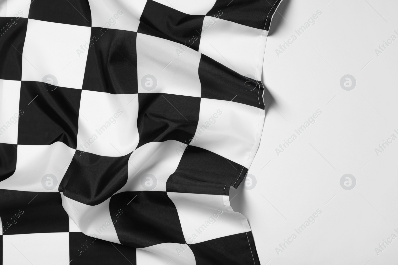 Photo of Checkered finish flag on white background, top view. Space for text