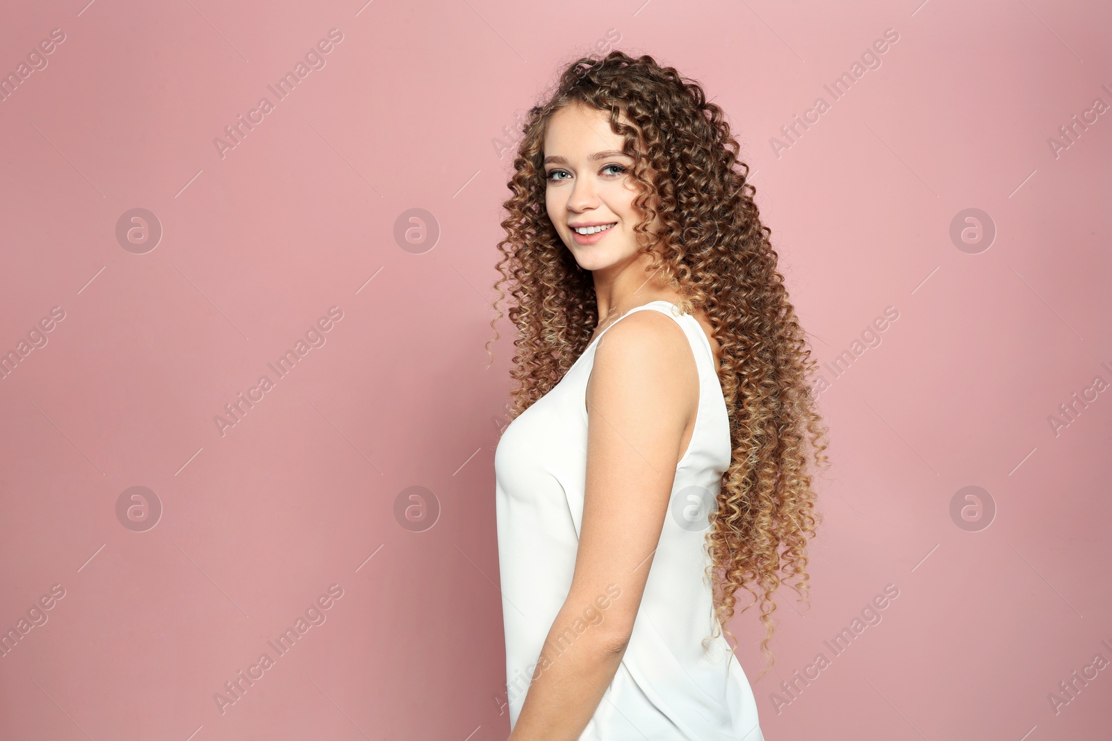 Photo of Portrait of beautiful young woman with shiny wavy hair on color background