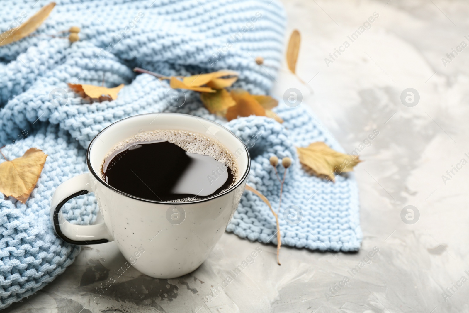 Photo of Composition with hot drink and warm plaid on grey table