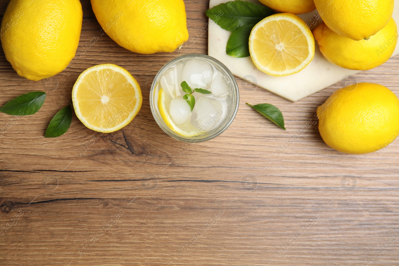 Photo of Cool freshly made lemonade and fruits on wooden table, flat lay. Space for text