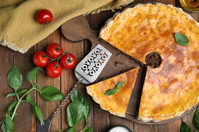 Delicious pie with minced meat, tomatoes and basil on wooden table, flat lay