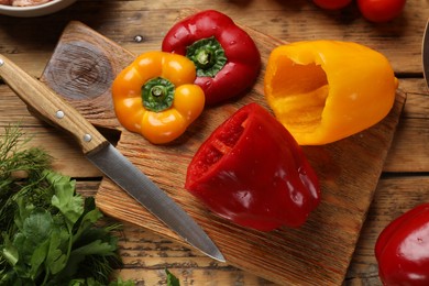 Making stuffed peppers. Fresh vegetables and knife on wooden table, flat lay