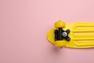 Photo of Skateboard on pink background, top view. Space for text