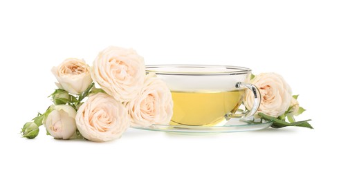 Photo of Aromatic herbal tea in glass cup and roses isolated on white