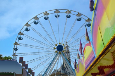 Photo of Beautiful large observation wheel in amusement park against blue sky