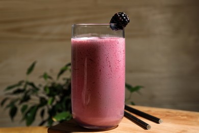 Photo of Glass of blackberry smoothie on wooden table