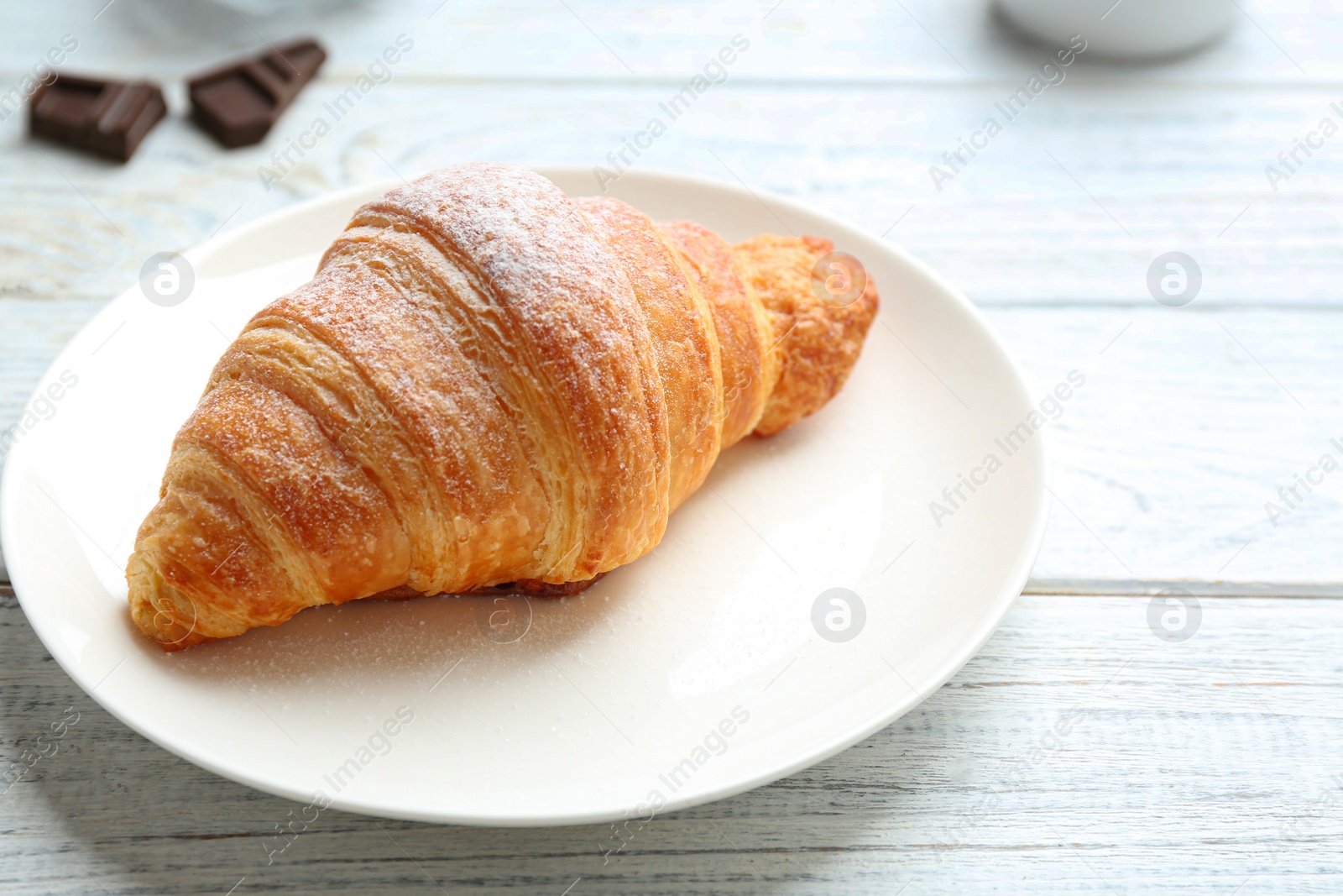 Photo of Plate with tasty croissant on white wooden table, closeup. French pastry