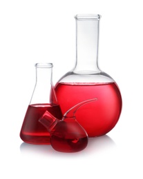 Set of laboratory glassware with red liquid on white background