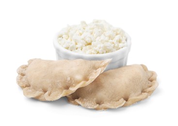 Raw dumplings (varenyky) and bowl with cottage cheese on white background