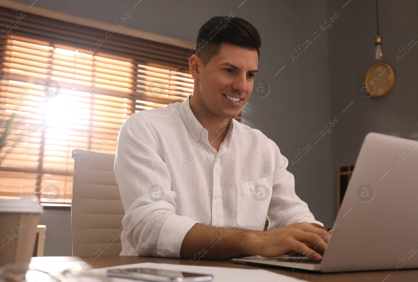 Photo of Freelancer working on laptop at table indoors