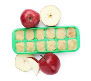Photo of Apple puree in ice cube tray and ingredients on white background, top view. Ready for freezing