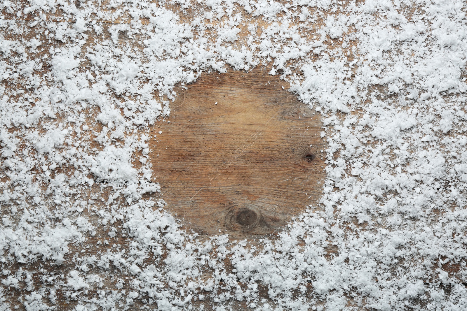 Photo of Frame made of snow on wooden background, top view with space for text. Winter season