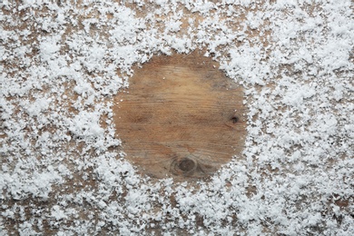 Photo of Frame made of snow on wooden background, top view with space for text. Winter season