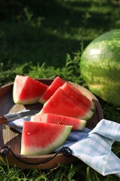 Photo of Tasty ripe watermelons on green grass outdoors