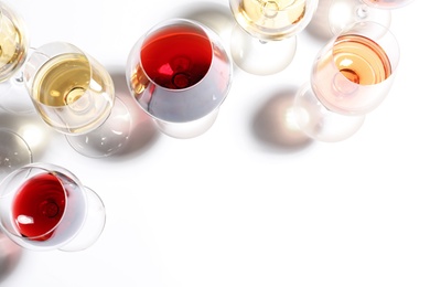 Different glasses with wine on white background, top view