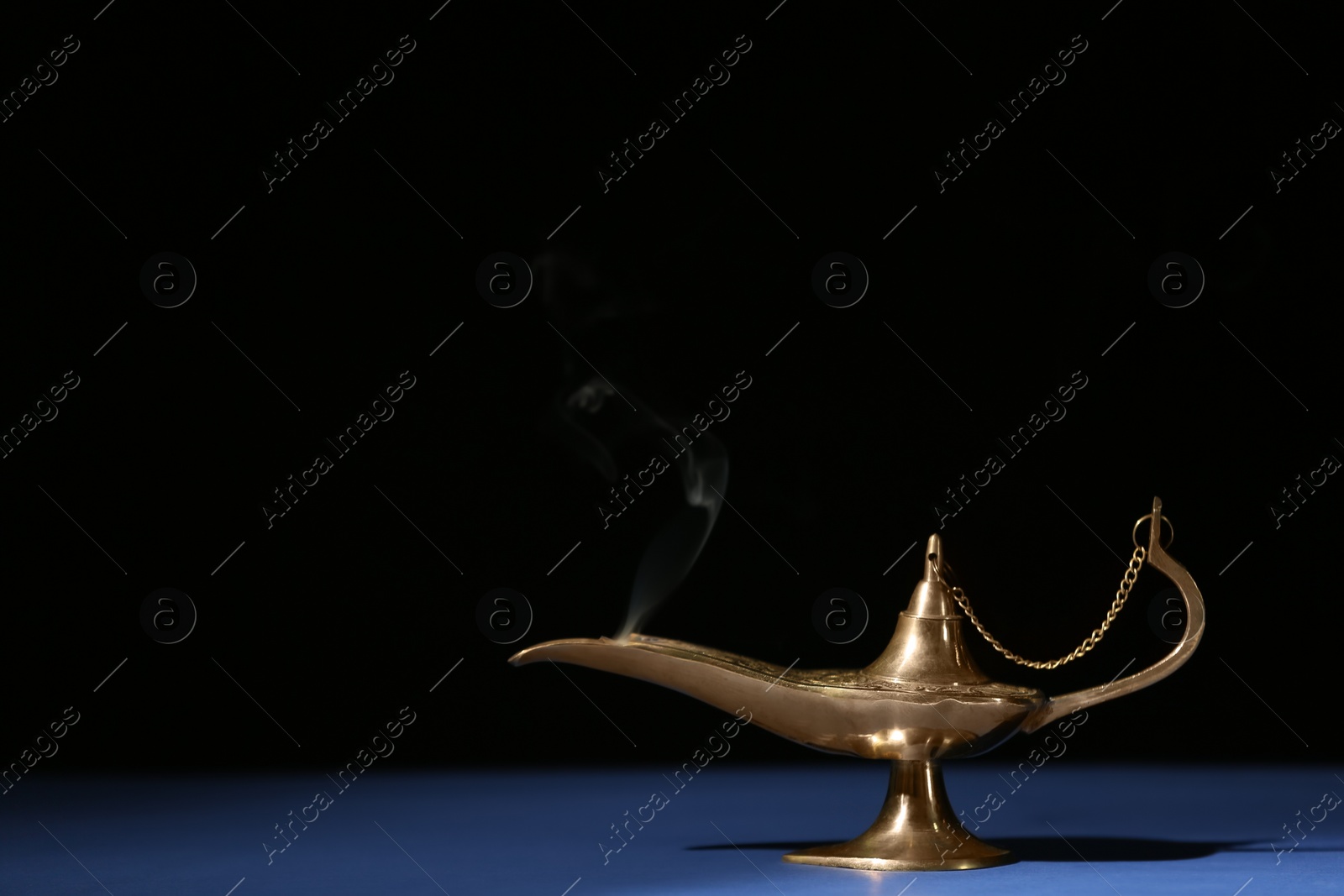 Photo of Aladdin lamp of wishes on table against black background