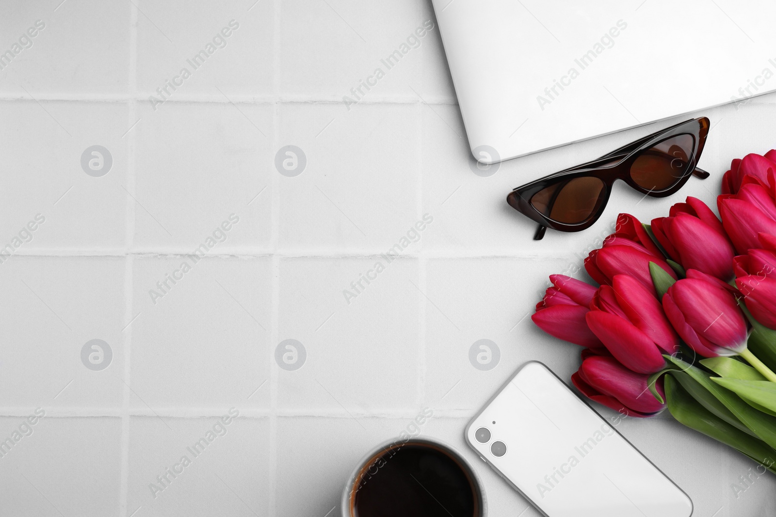 Photo of Flat lay composition with beautiful tulips and smartphone on white table. Space for text