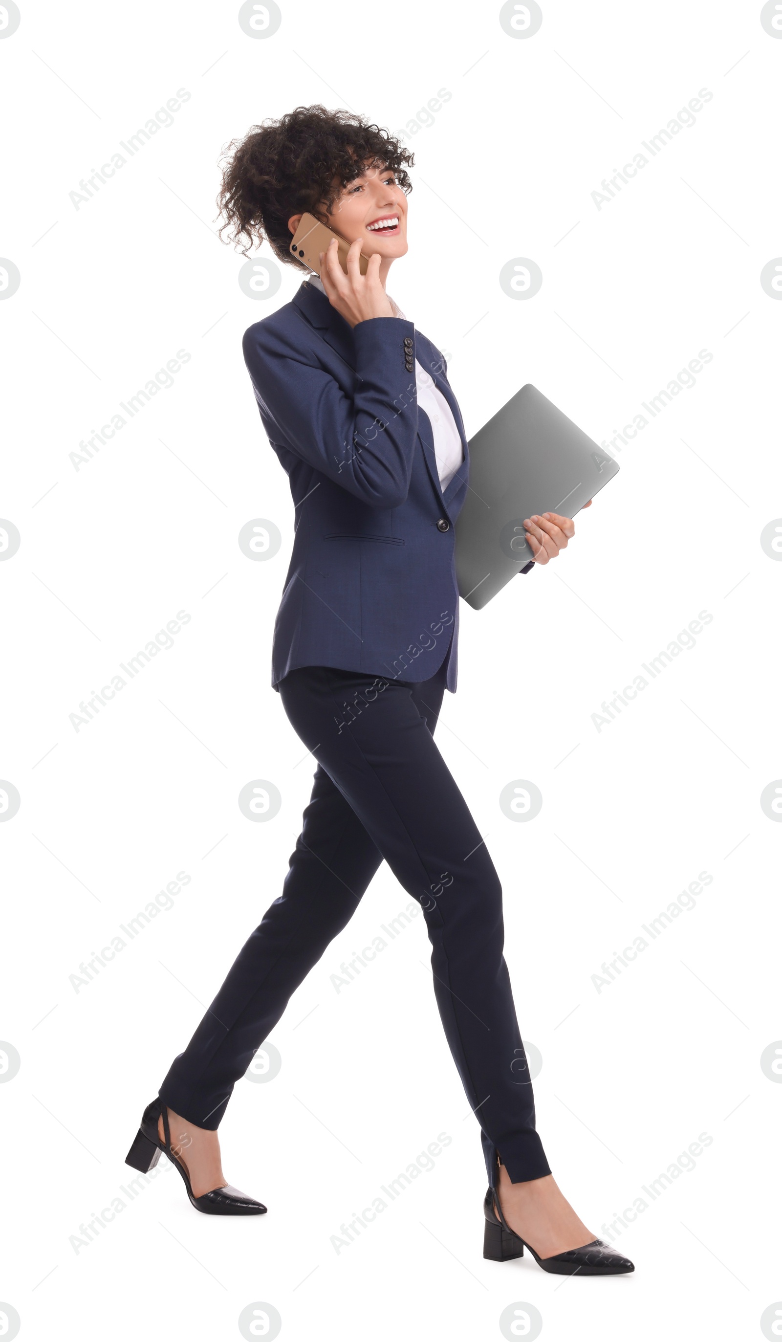 Photo of Beautiful businesswoman in suit with laptop talking on smartphone against white background