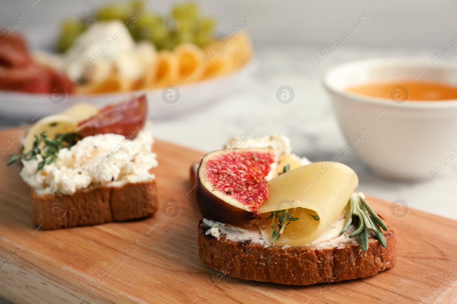 Photo of Sandwich with ripe fig and cheese on wooden board, closeup