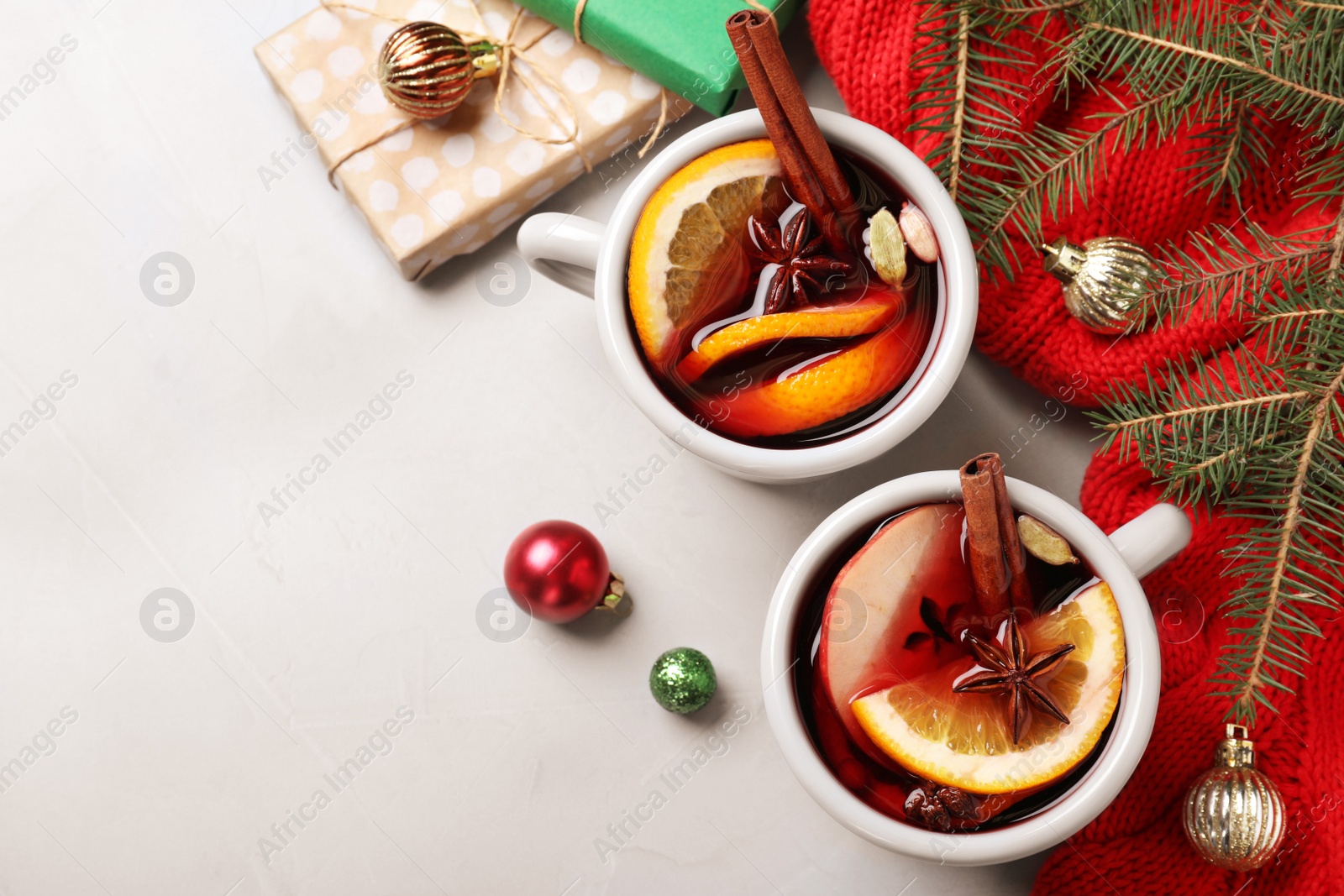 Photo of Cups of tasty mulled wine on grey background, flat lay. Space for text