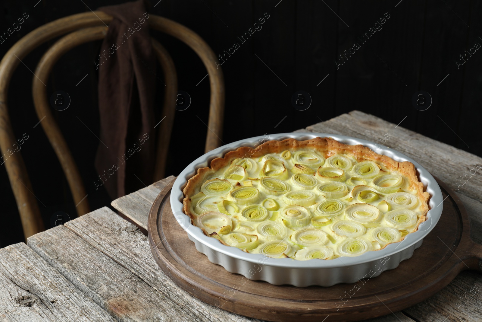 Photo of Freshly baked leek pie on old wooden table. Space for text