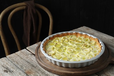 Freshly baked leek pie on old wooden table. Space for text