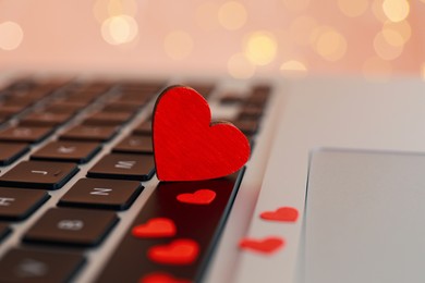 Hearts on laptop keyboard, closeup. Online dating concept