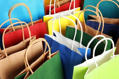 Photo of Colorful paper shopping bags as background, closeup