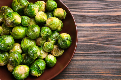 Delicious roasted Brussels sprouts on wooden table, top view