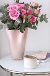 Cup of coffee and flowers on table