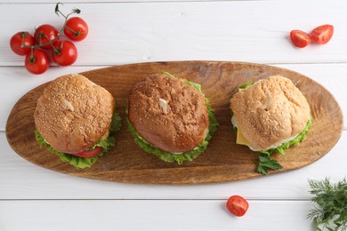 Photo of Delicious vegetarian burgers served on white wooden table, top view