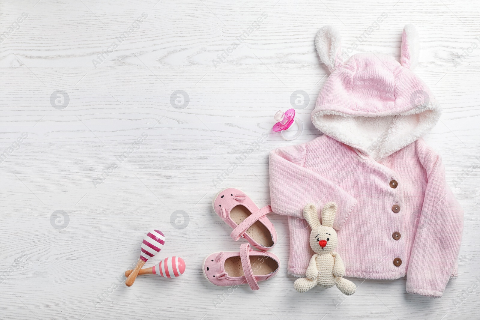 Photo of Flat lay composition with cute clothes and space for text on white wooden background. Baby accessories