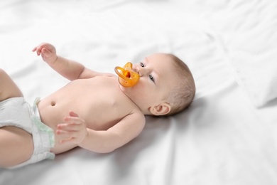 Cute little baby lying on bed at home