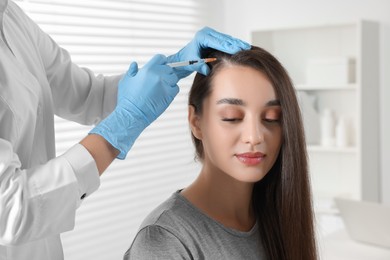 Photo of Trichologist giving injection to patient in clinic, closeup