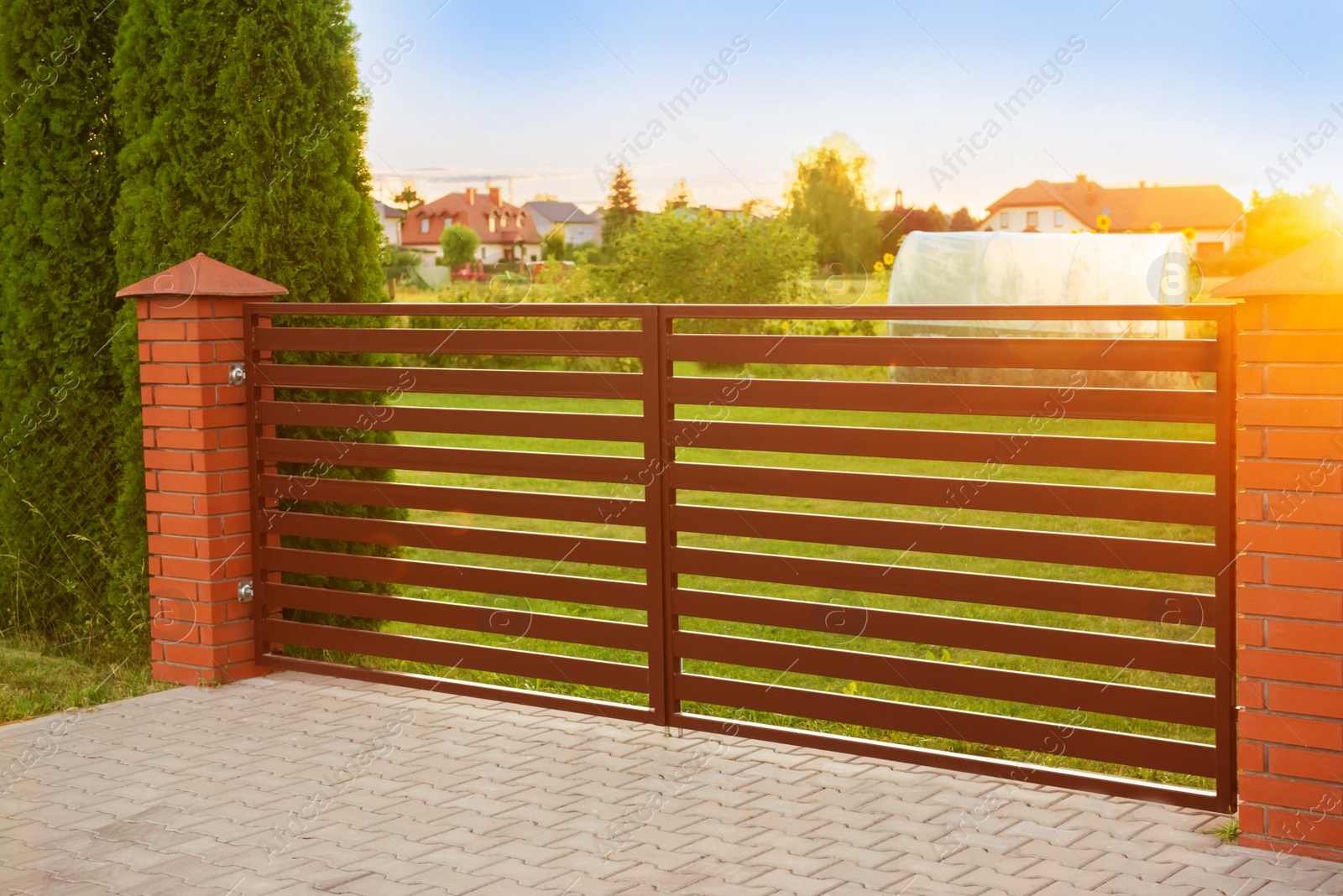 Photo of Beautiful brick fence with iron panels outdoors