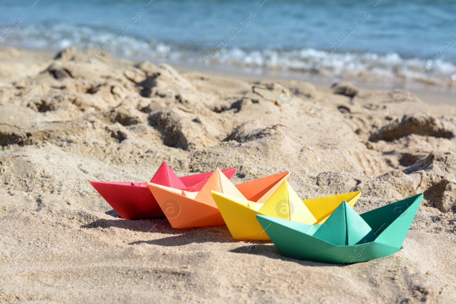 Photo of Many paper boats near sea on sunny day