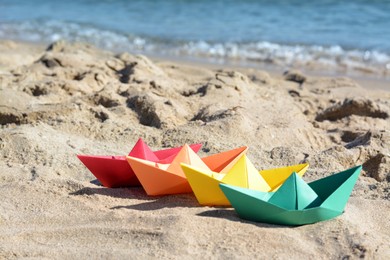 Photo of Many paper boats near sea on sunny day
